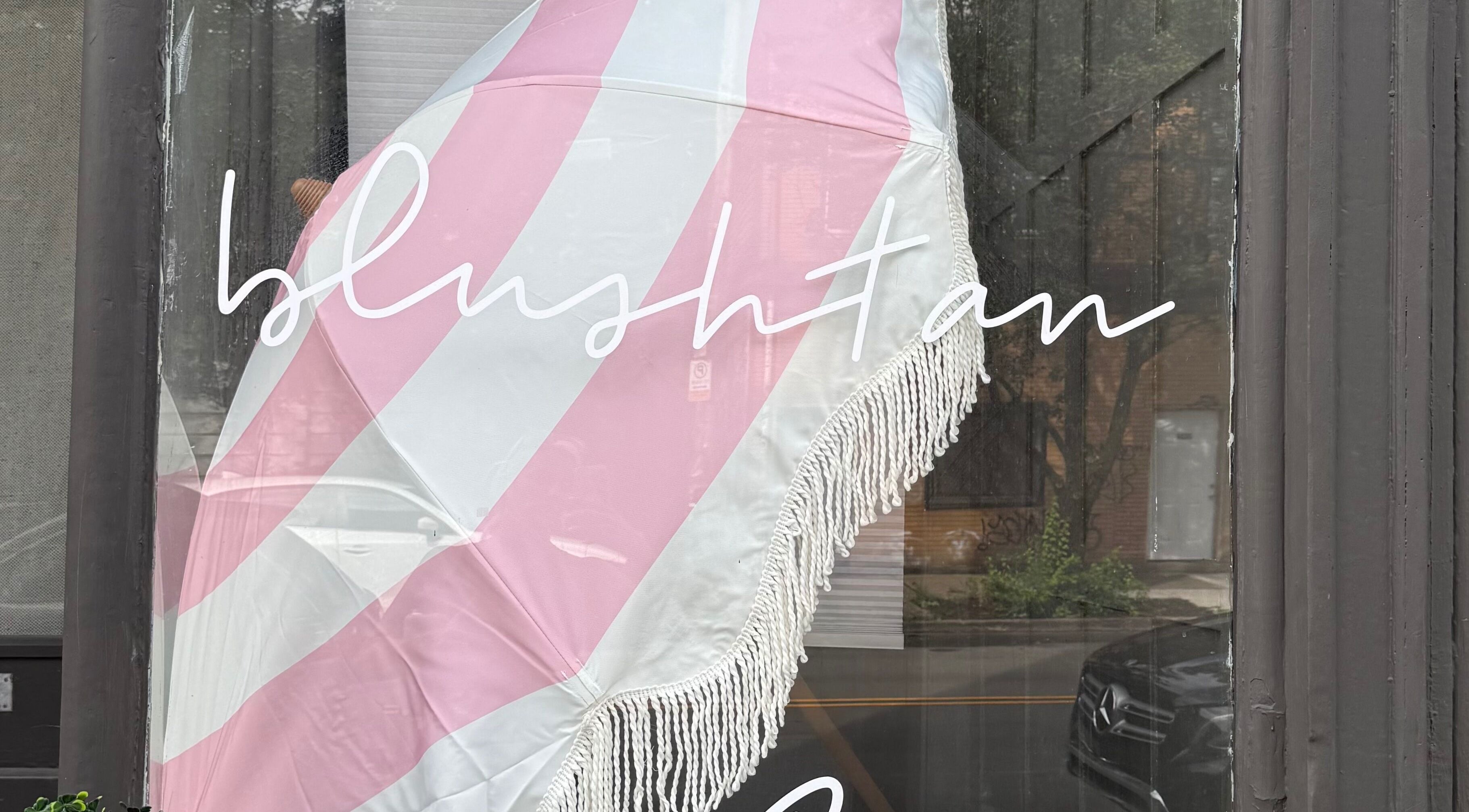 BlushTan Lawrenceville storefront with pink parasol, located in Pittsburgh, Pennsylvania, US.