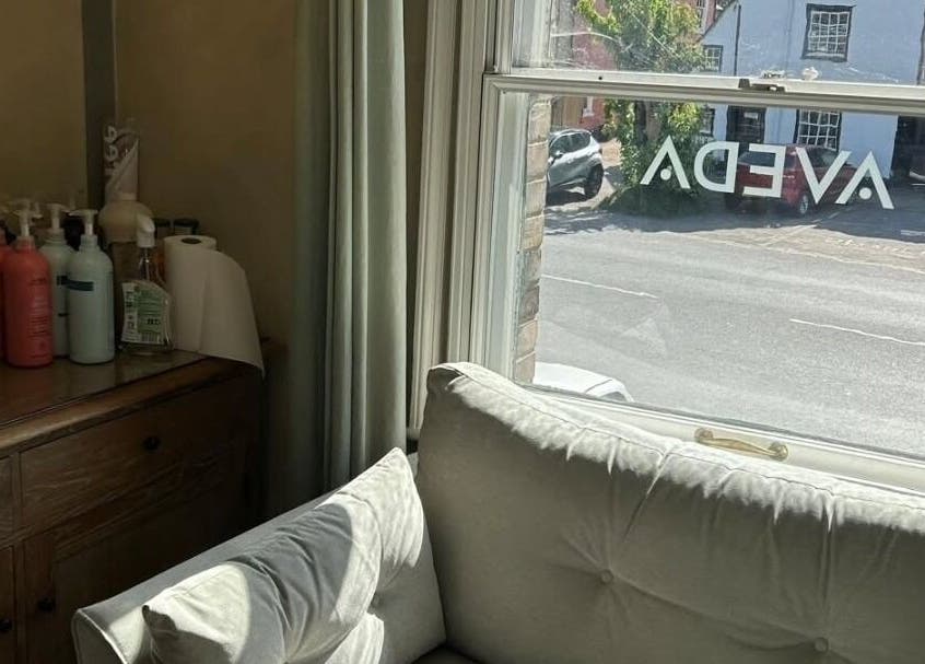 Comfortable seating in Pure Elements, Long Melford, England, GB with Aveda products on a side table.