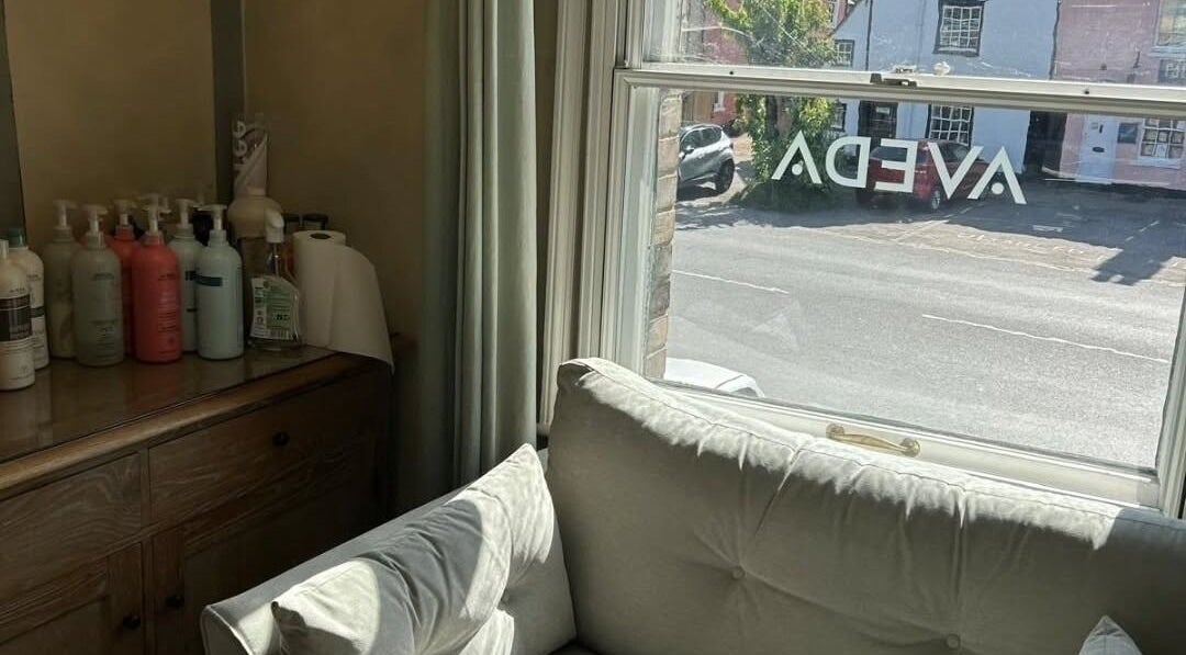 Comfortable seating in Pure Elements, Long Melford, England, GB with Aveda products on a side table.