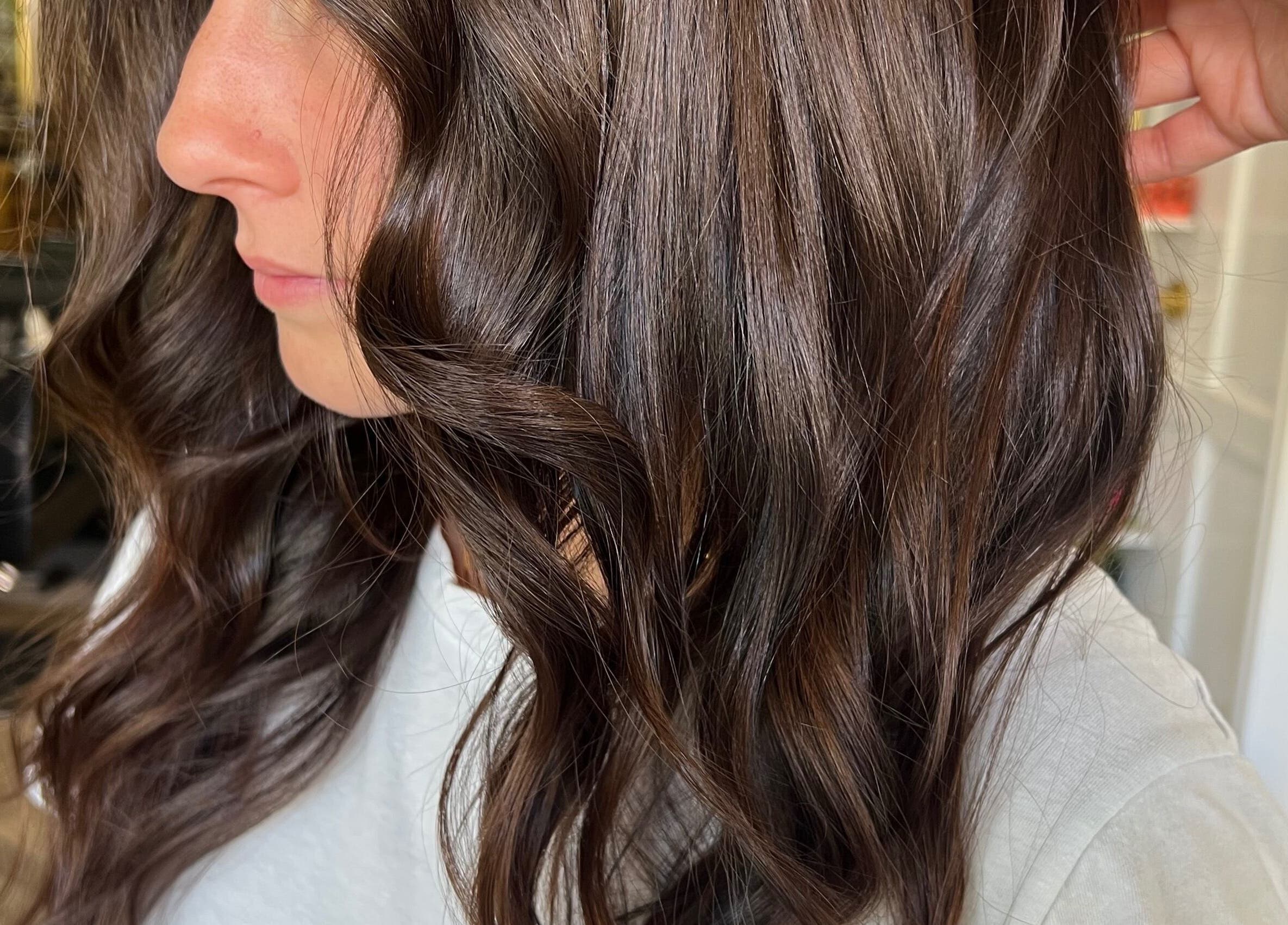 Close-up of glossy brown wavy hair styled at Yani Mendez x Vion Salon, Boca Raton, Florida, US.