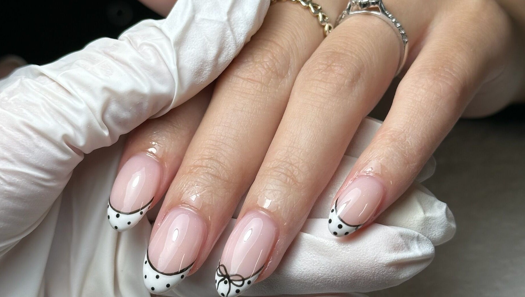 Close-up of chic nail art with bows at Onn Nails, Stockport, England, GB, showcasing detailed manicure.