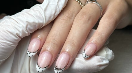 Close-up of chic nail art with bows at Onn Nails, Stockport, England, GB, showcasing detailed manicure.