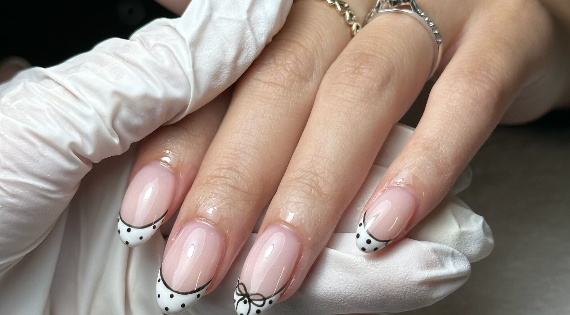 Close-up of chic nail art with bows at Onn Nails, Stockport, England, GB, showcasing detailed manicure.