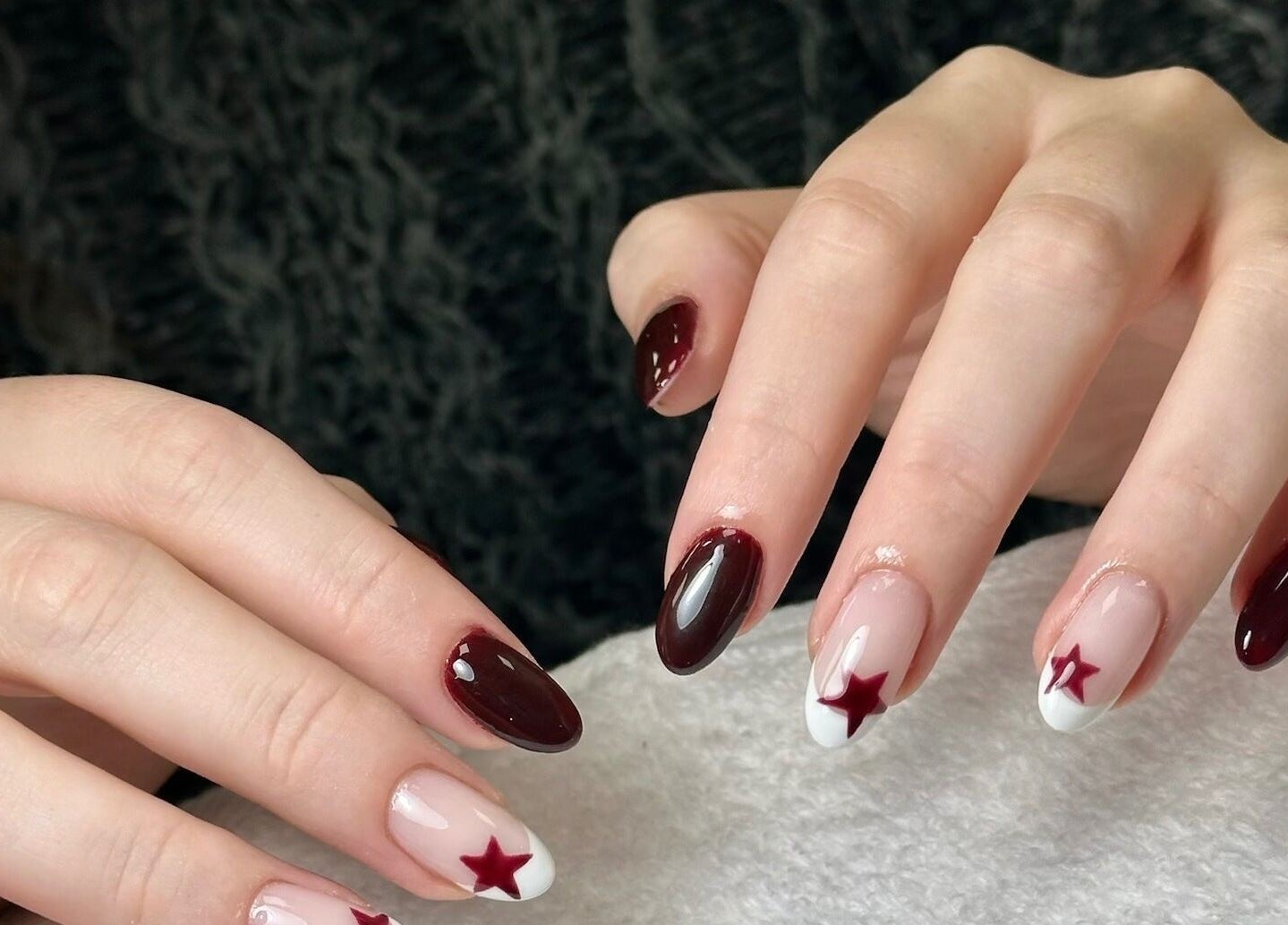 Elegant star-themed nail art at Onn Nails, Stockport, England, GB, showcasing burgundy and white designs.