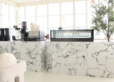 Elegant coffee bar at Layers Spa in Riyadh, Riyadh Province, SA with marble decor and modern seating.
