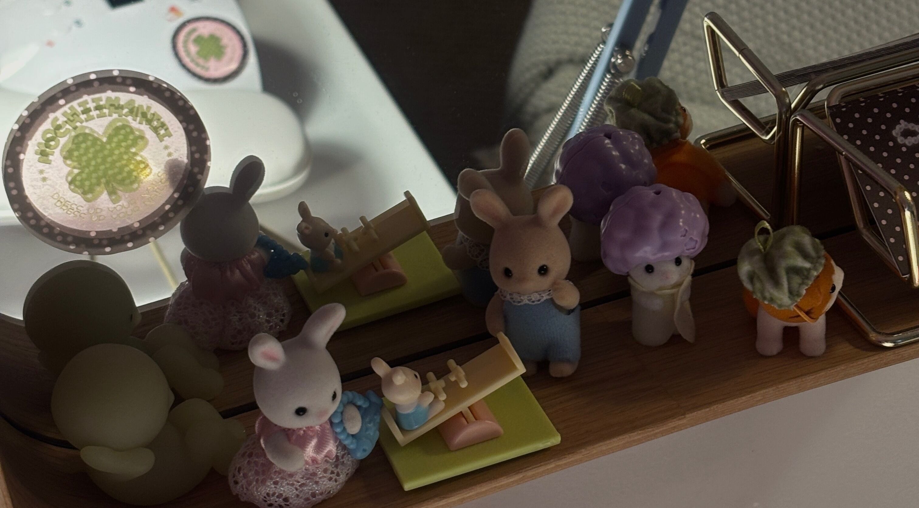 Cute toy figurines and a Mochiimanii clover logo mirrored in Yeronga, Queensland, AU wellness venue.