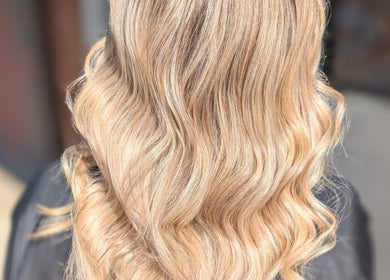 Blonde wavy hairstyle created at Hair By Jaimie in Melbourne, Victoria, AU, showcasing elegant curls.