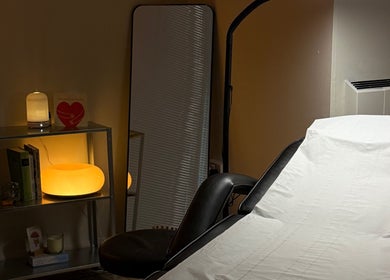 Cozy treatment room at emstudio in Clydebank, Scotland, GB, featuring a padded bed and soft ambient lighting.