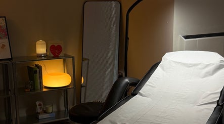 Cozy treatment room at emstudio in Clydebank, Scotland, GB, featuring a padded bed and soft ambient lighting.