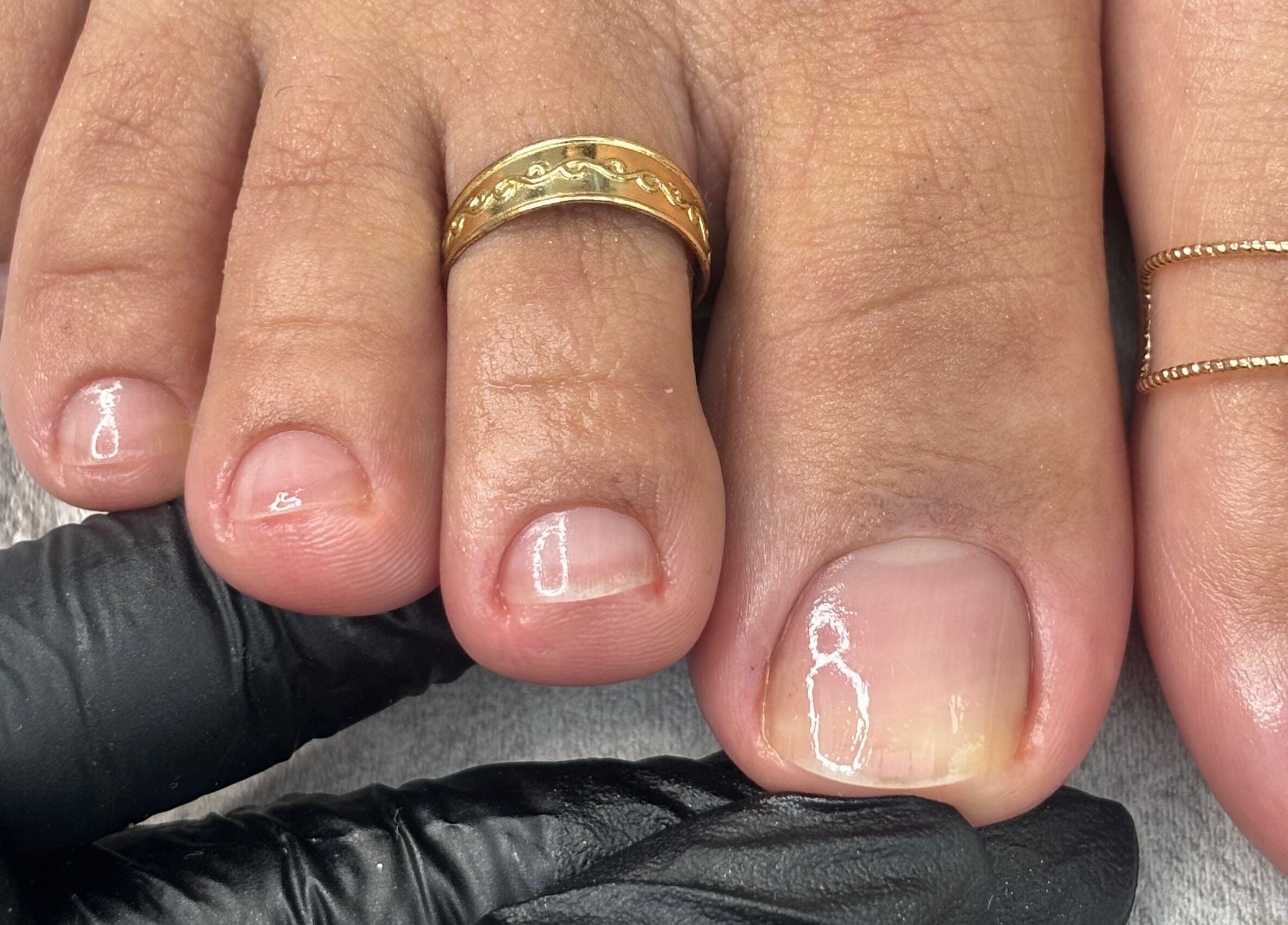 Close-up of manicured toenails with gold rings at Mani.festation.nbt, Mountsorrel, England, GB.