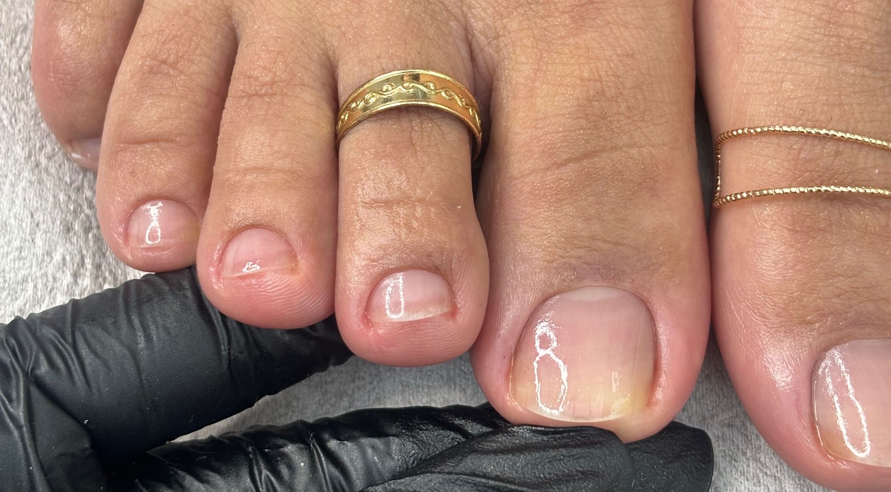 Close-up of manicured toenails with gold rings at Mani.festation.nbt, Mountsorrel, England, GB.