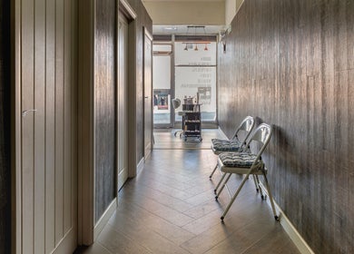 Elegant hallway at It's Angies, London, England, GB with sleek wood walls and plush seating.