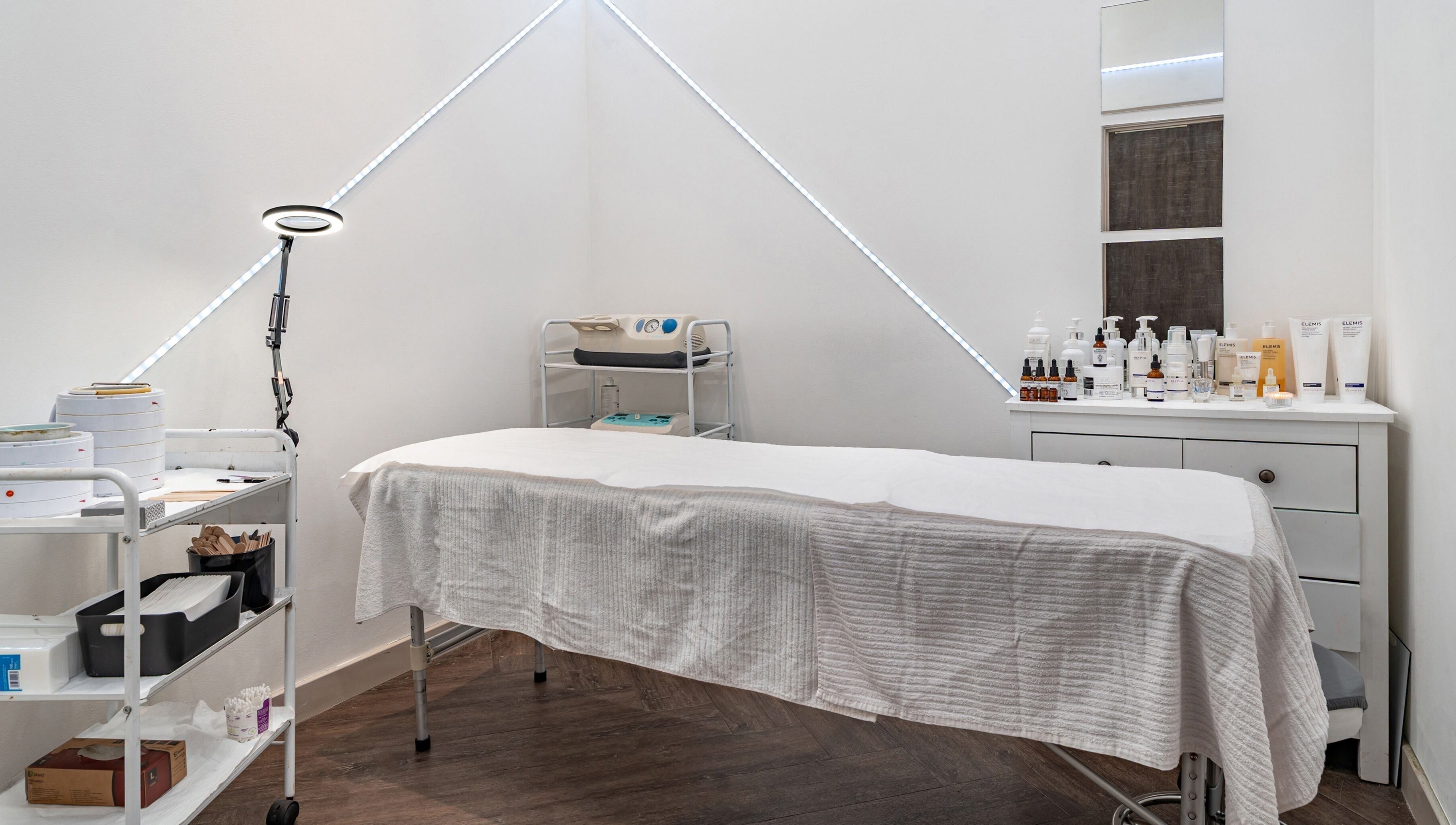 Spa treatment room with a massage table and products at It's Angies, London, England, GB.