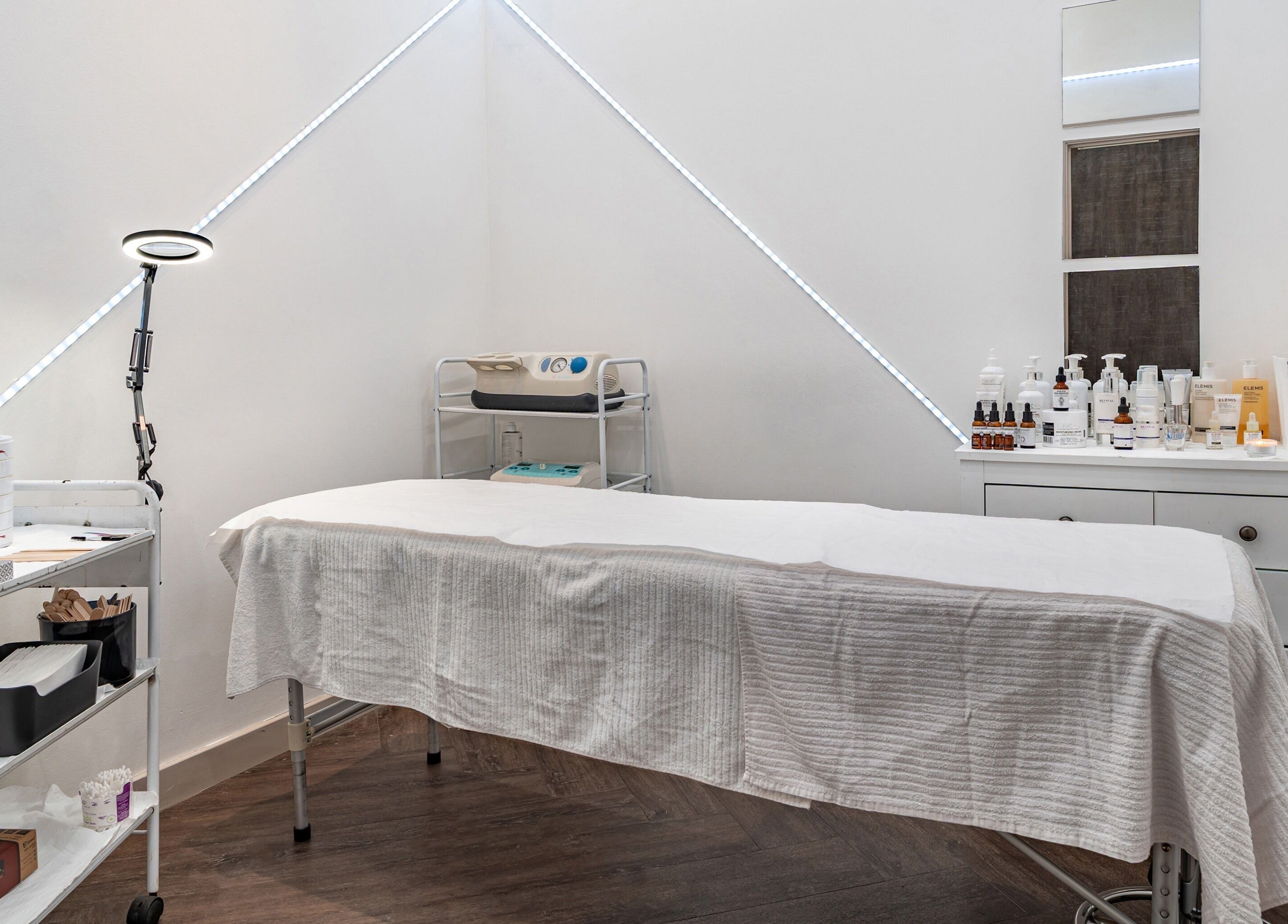 Spa treatment room with a massage table and products at It's Angies, London, England, GB.