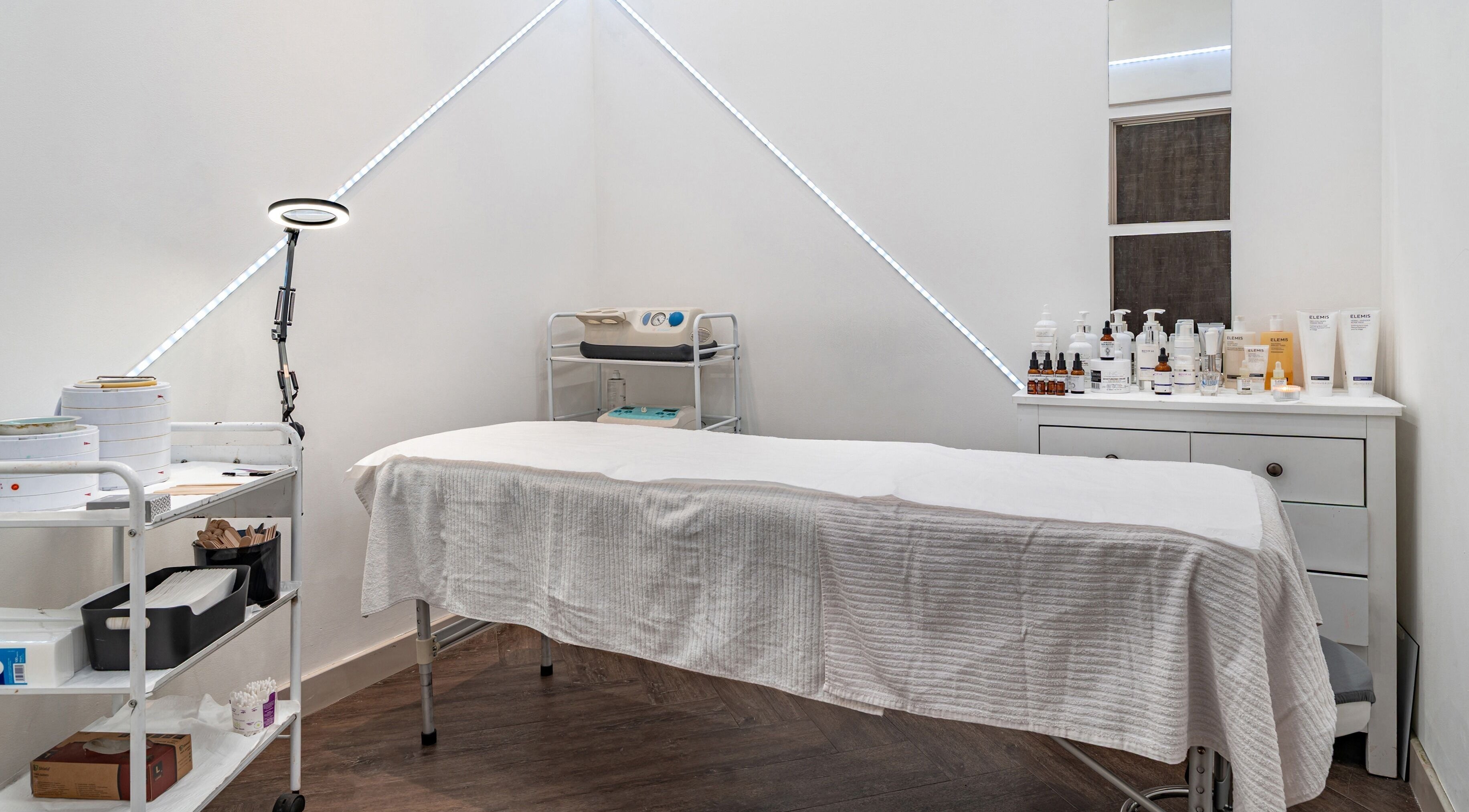 Spa treatment room with a massage table and products at It's Angies, London, England, GB.