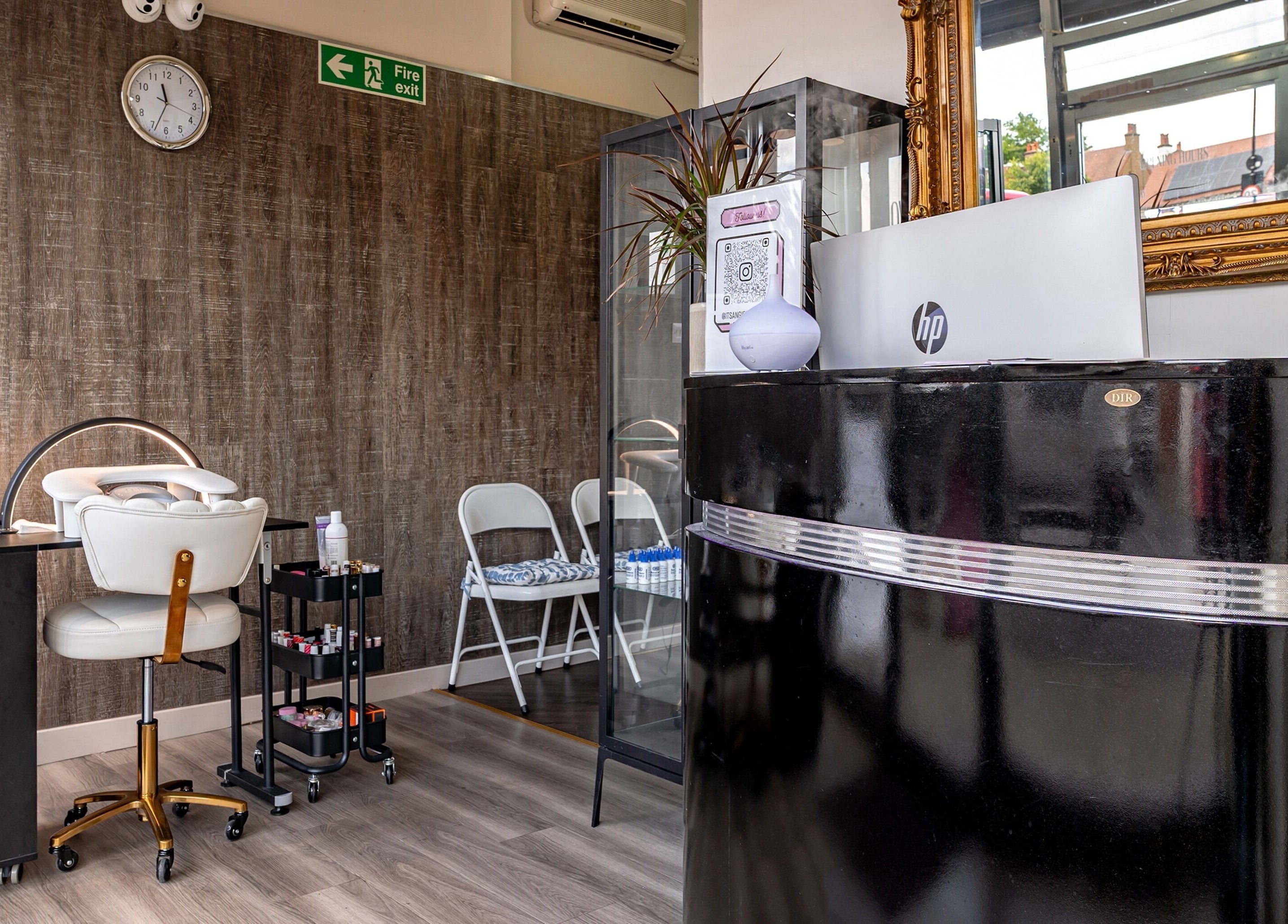 Reception and nail care station at It's Angies, London, England, GB. Modern interior with brown textured walls.