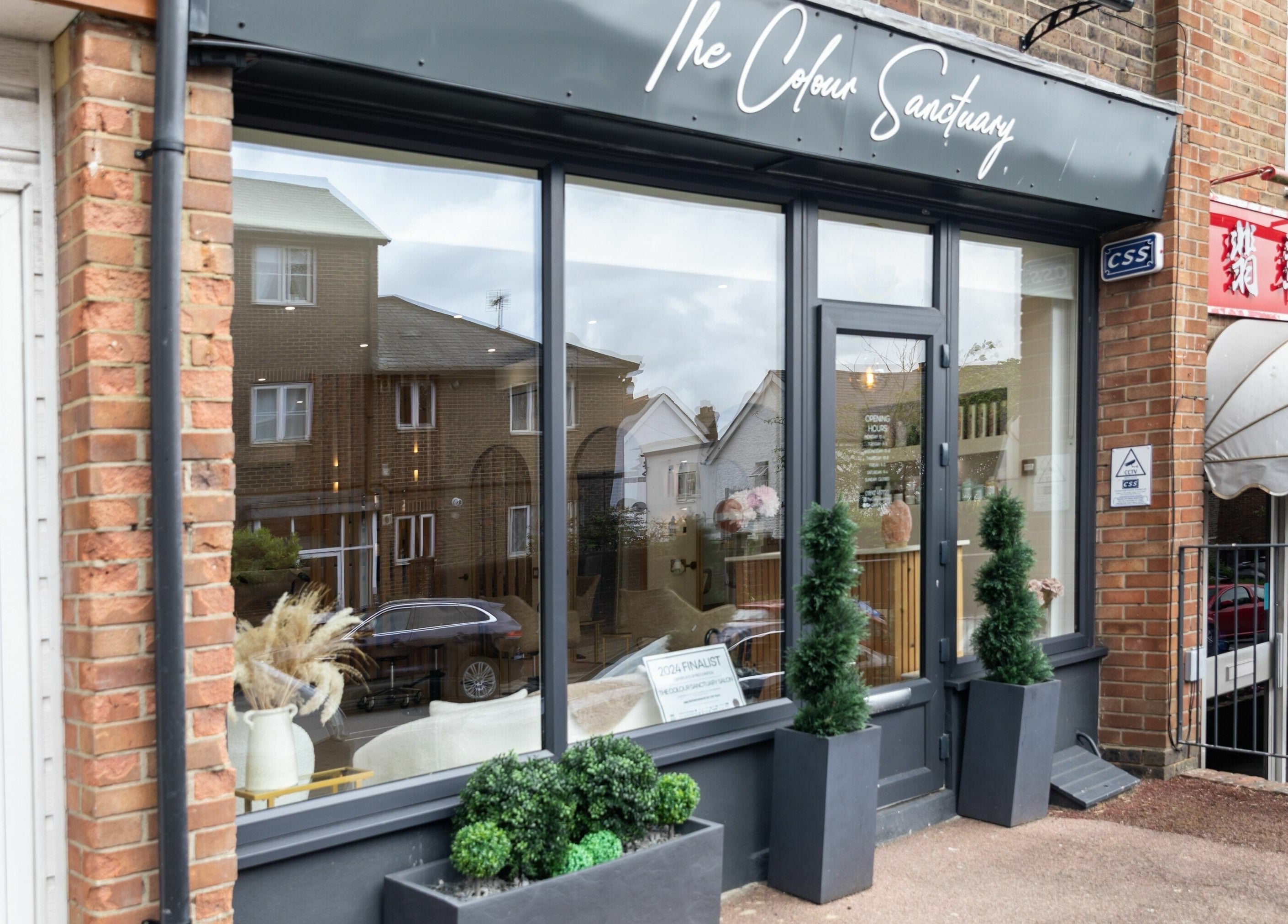 Front view of The Colour Sanctuary in Crowborough, England, GB showing large windows and decorative plants.