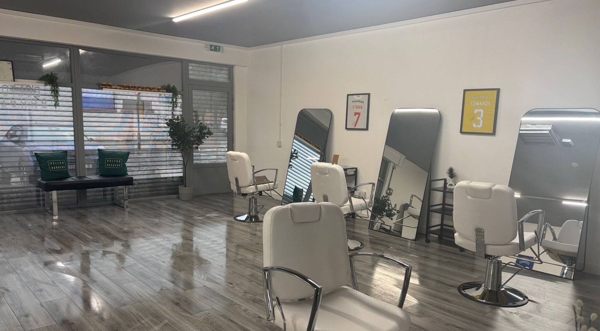 Interior of Bolton Barbers in Stirling, Scotland, GB, featuring stylish chairs and large mirrors.