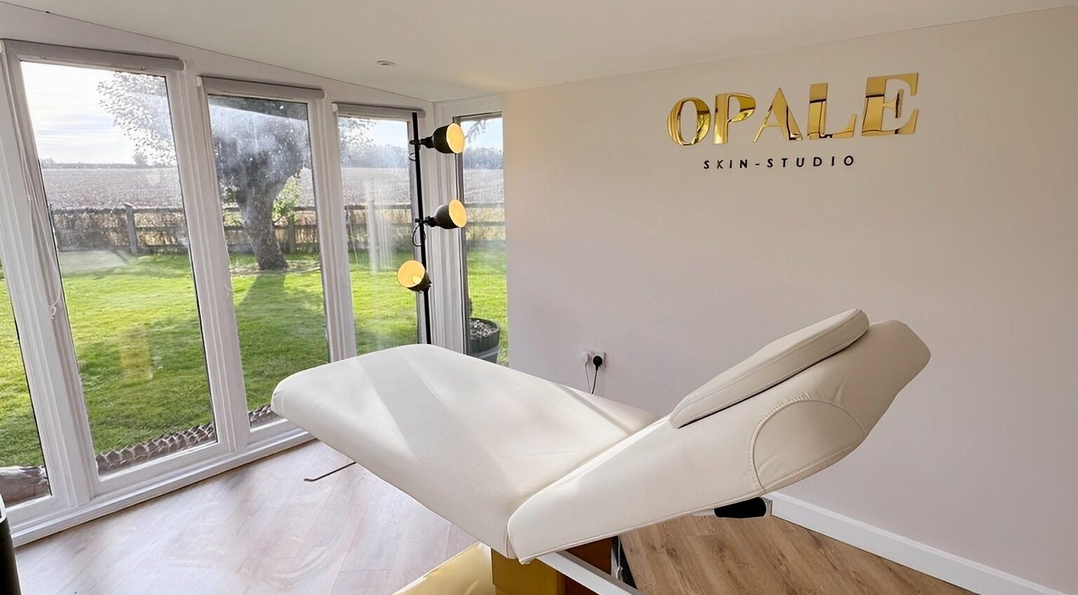 Relaxing treatment room at Opale Skin Studio with garden view in Foxearth, England, GB.