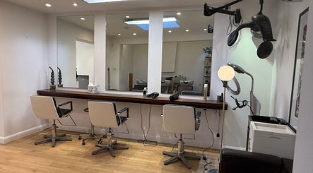 Interior of Gianni Hair salon in London, England, GB, featuring modern styling chairs and mirrors.