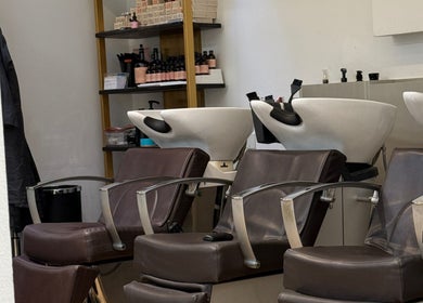 Chic hair wash stations at Gianni Hair, London, England, GB, featuring sleek brown chairs and modern bowls.
