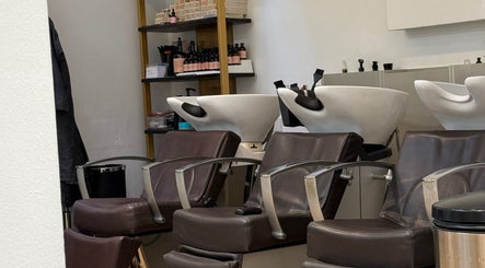Chic hair wash stations at Gianni Hair, London, England, GB, featuring sleek brown chairs and modern bowls.