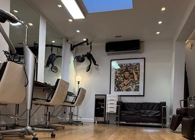 Chic interior of Gianni Hair salon in London, England, GB, featuring modern chairs and stylish decor.