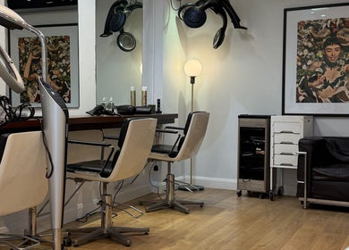 Modern salon interior at Gianni Hair, London, England, GB with sleek chairs and stylish decor.