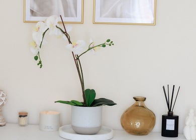 Serene ambiance at Gloss by Storm, Bowbrook, England with an orchid, candle, and decor enhancing wellness.