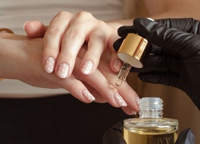 Nail treatment at Gloss by Storm, Bowbrook, England showcasing hydrating oil application on elegant manicure.
