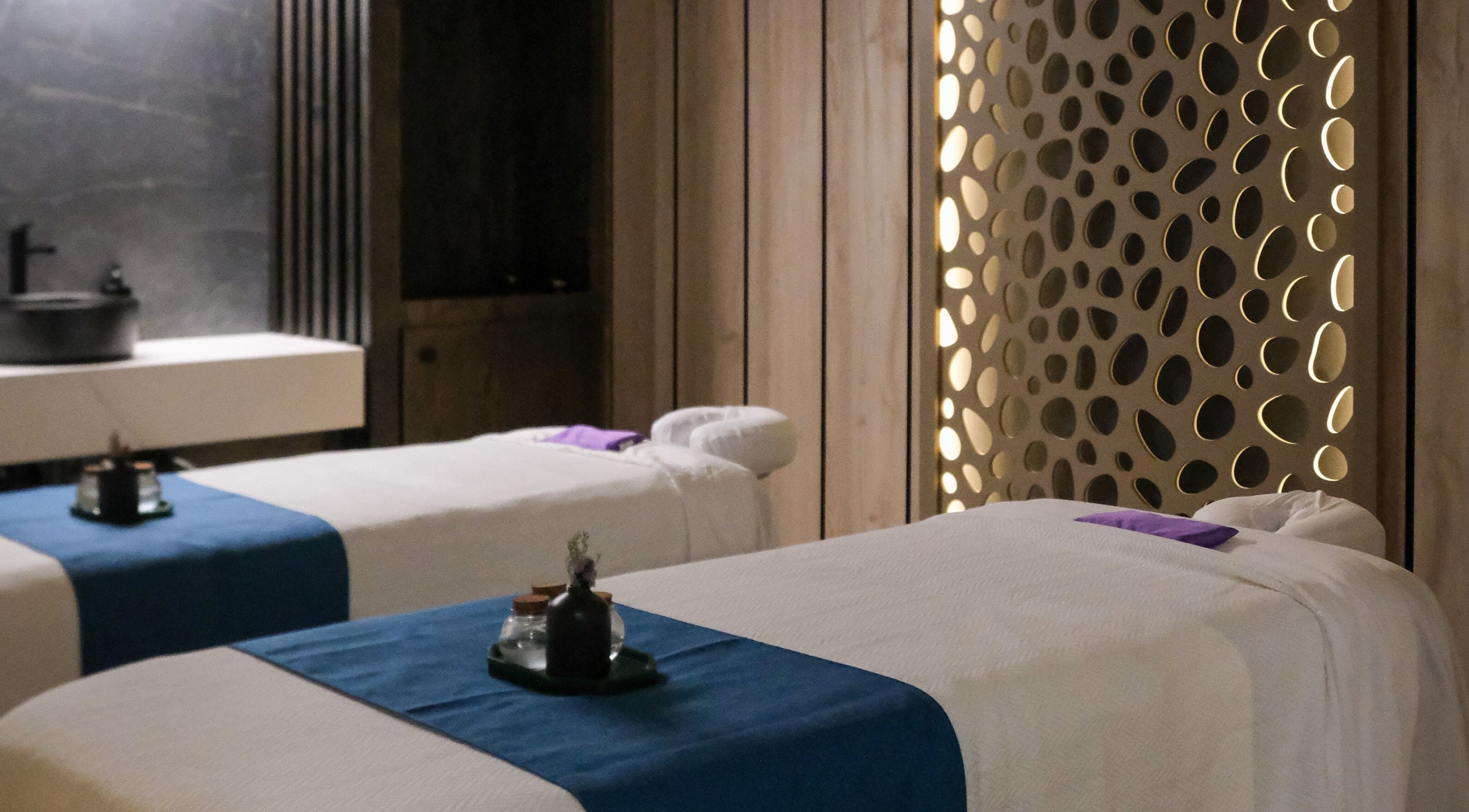 Luxury treatment room at Pamper Valley, Toronto, Ontario, CA with two massage tables and ambient lighting.