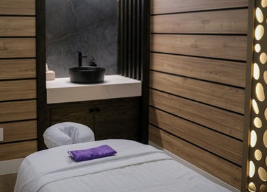 Tranquil spa room at Pamper Valley with wooden accents and massage table, located in Toronto, Ontario, CA.