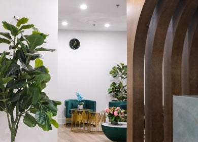 Elegant lounge at Pamper Valley, Toronto, Ontario, CA with lush plants and chic green seating.