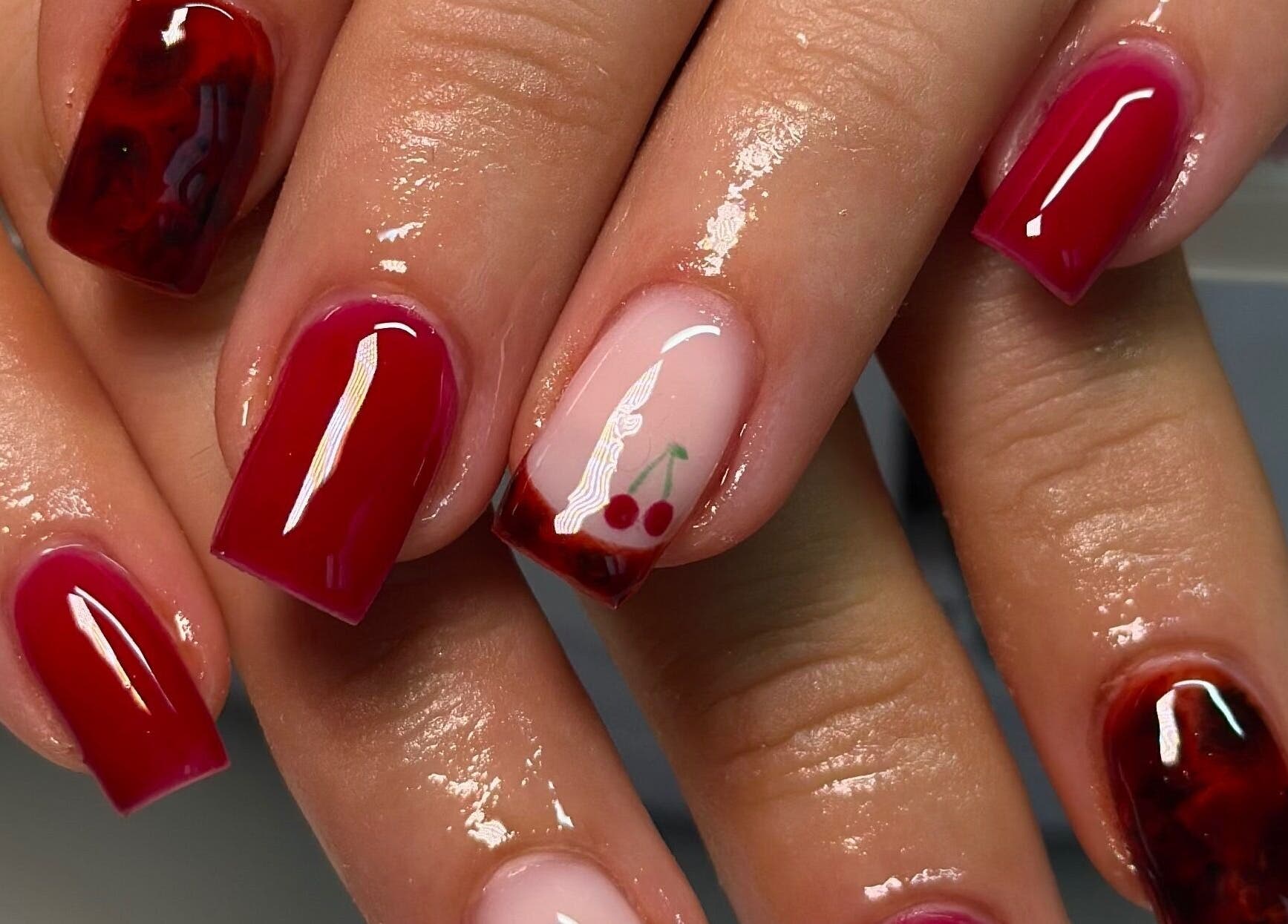 Elegant cherry nail art at Nails By CC in Chorley, England, GB, showcases vibrant red manicure designs.