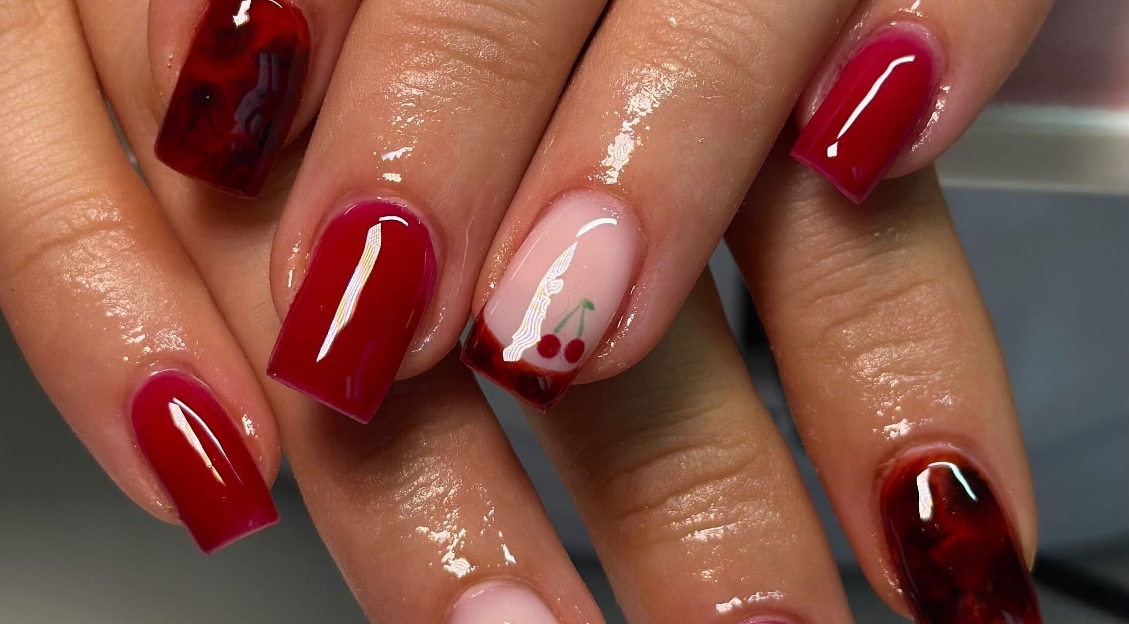 Elegant cherry nail art at Nails By CC in Chorley, England, GB, showcases vibrant red manicure designs.