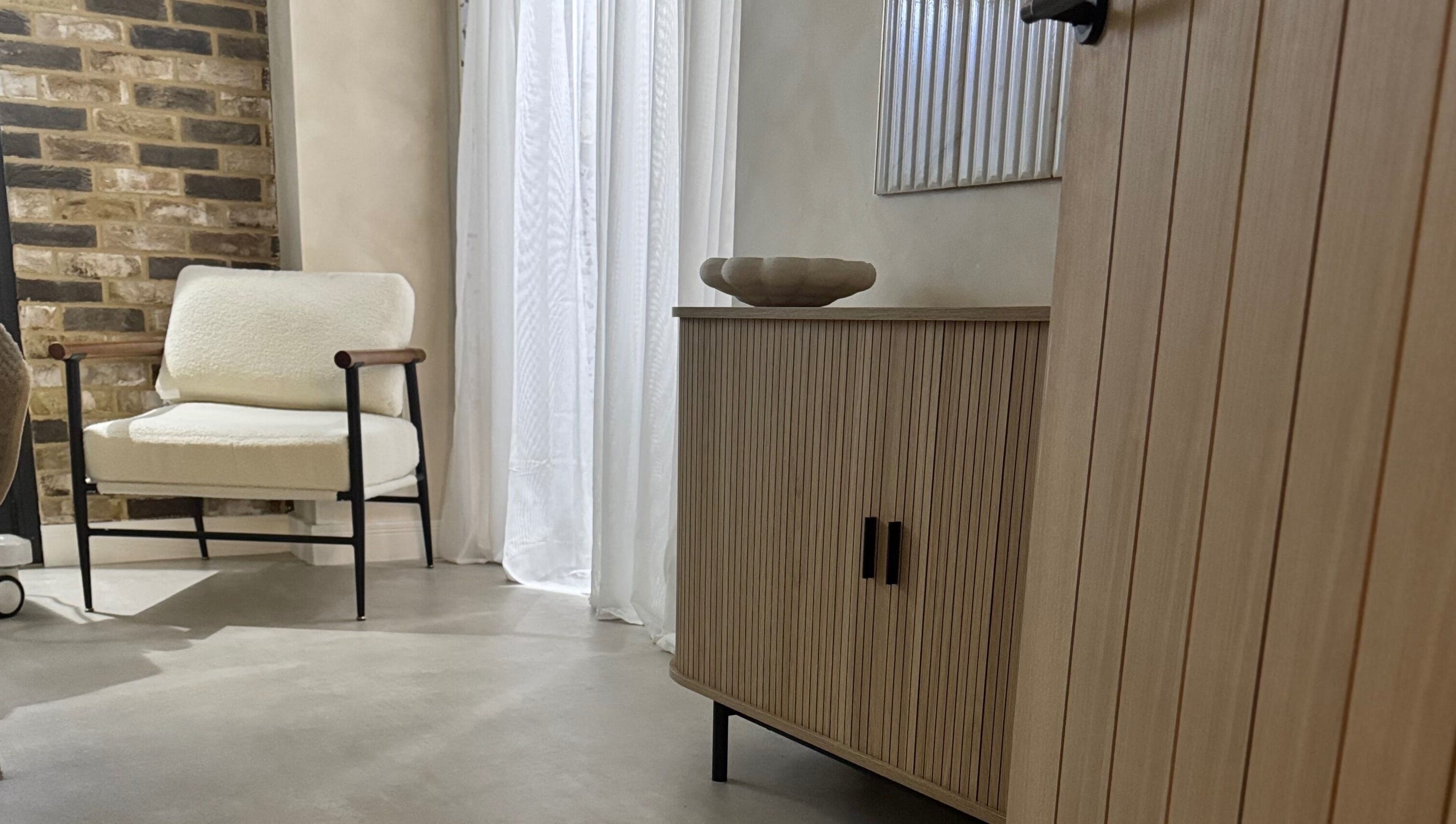 Modern seating area at Form Wellness Club, Sunderland, England, GB with cozy armchair and natural wood accents.