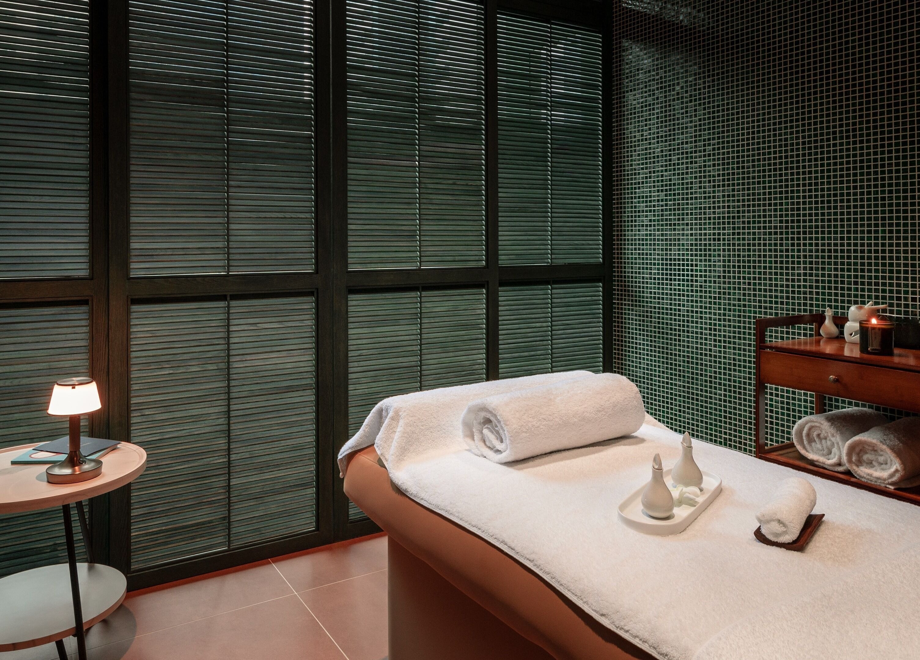 Tranquil treatment room at Lost/Found Spa, Hong Kong Island, featuring soft lighting and plush towels.