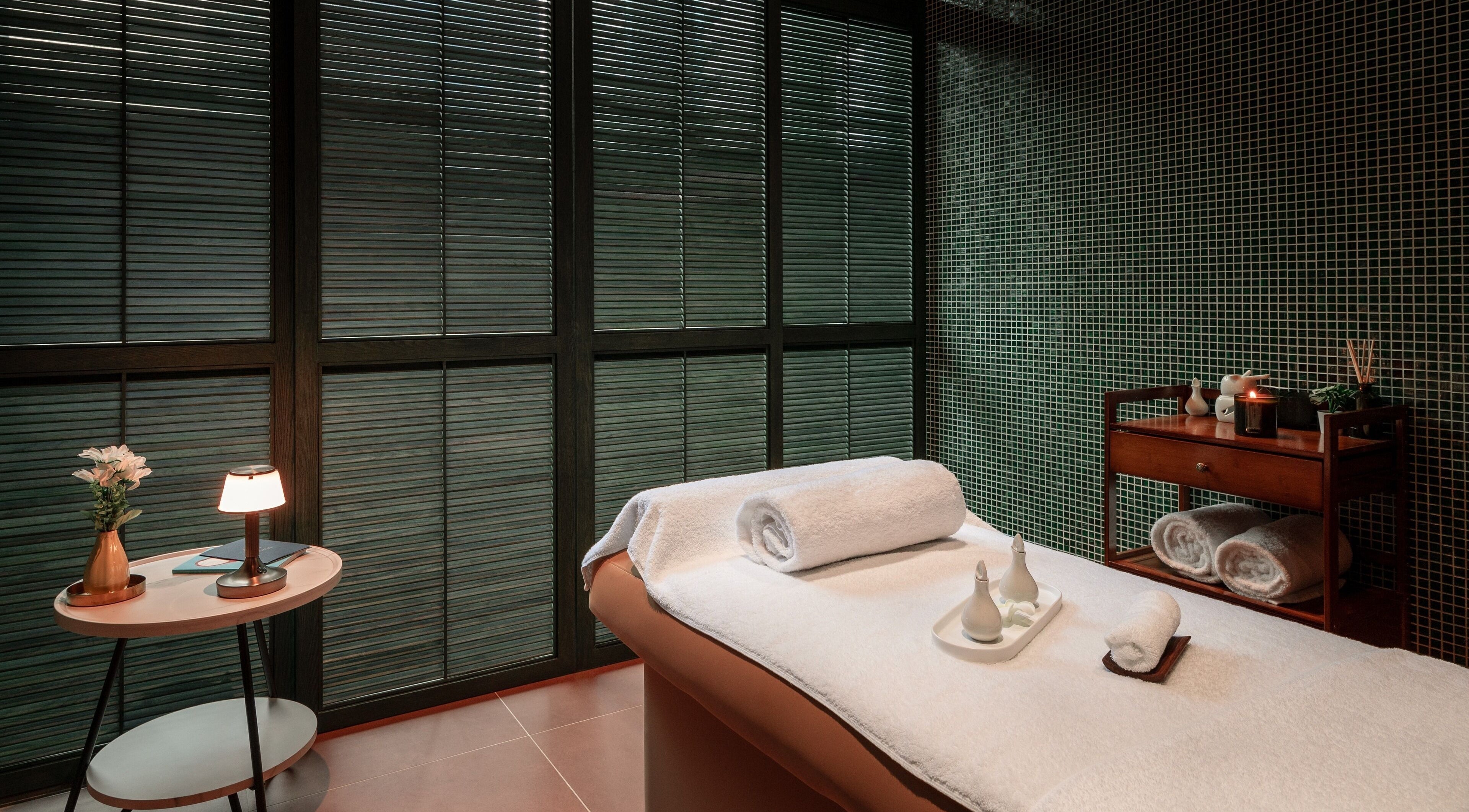 Tranquil treatment room at Lost/Found Spa, Hong Kong Island, featuring soft lighting and plush towels.