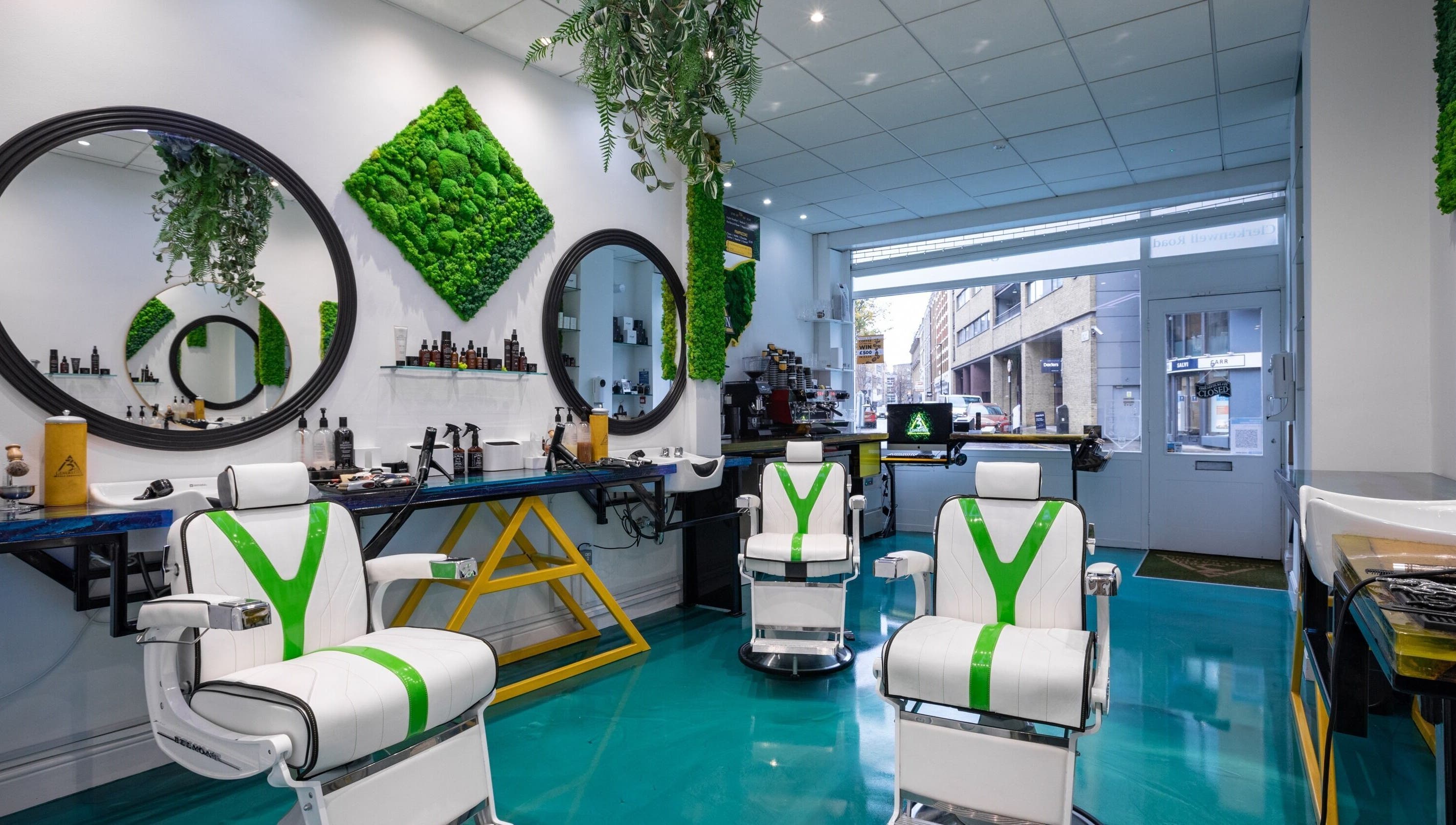 Modern barber chairs at 3rd Generation Grooming, London, England, GB, with lush green decor and sleek design.