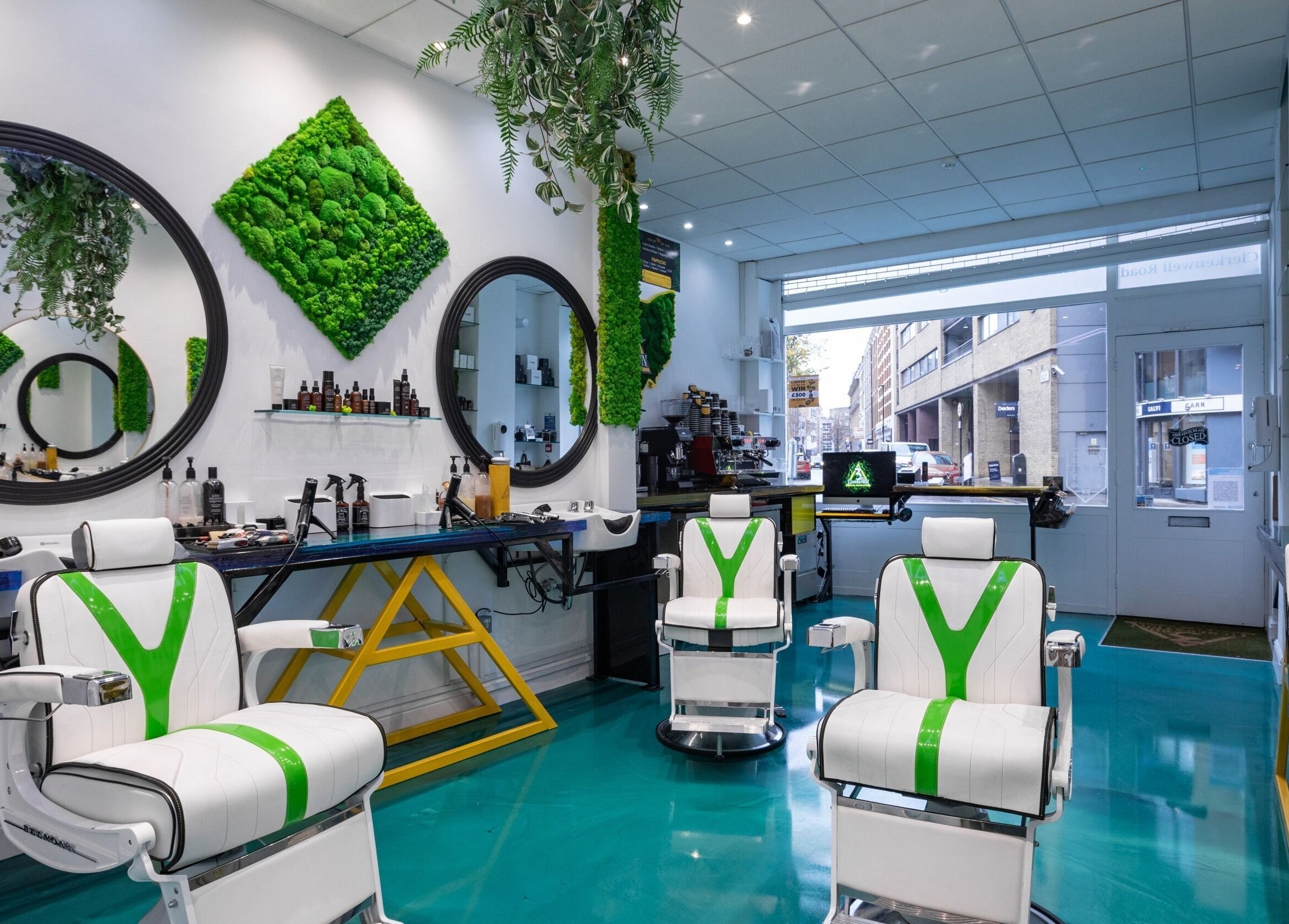 Modern barber chairs at 3rd Generation Grooming, London, England, GB, with lush green decor and sleek design.