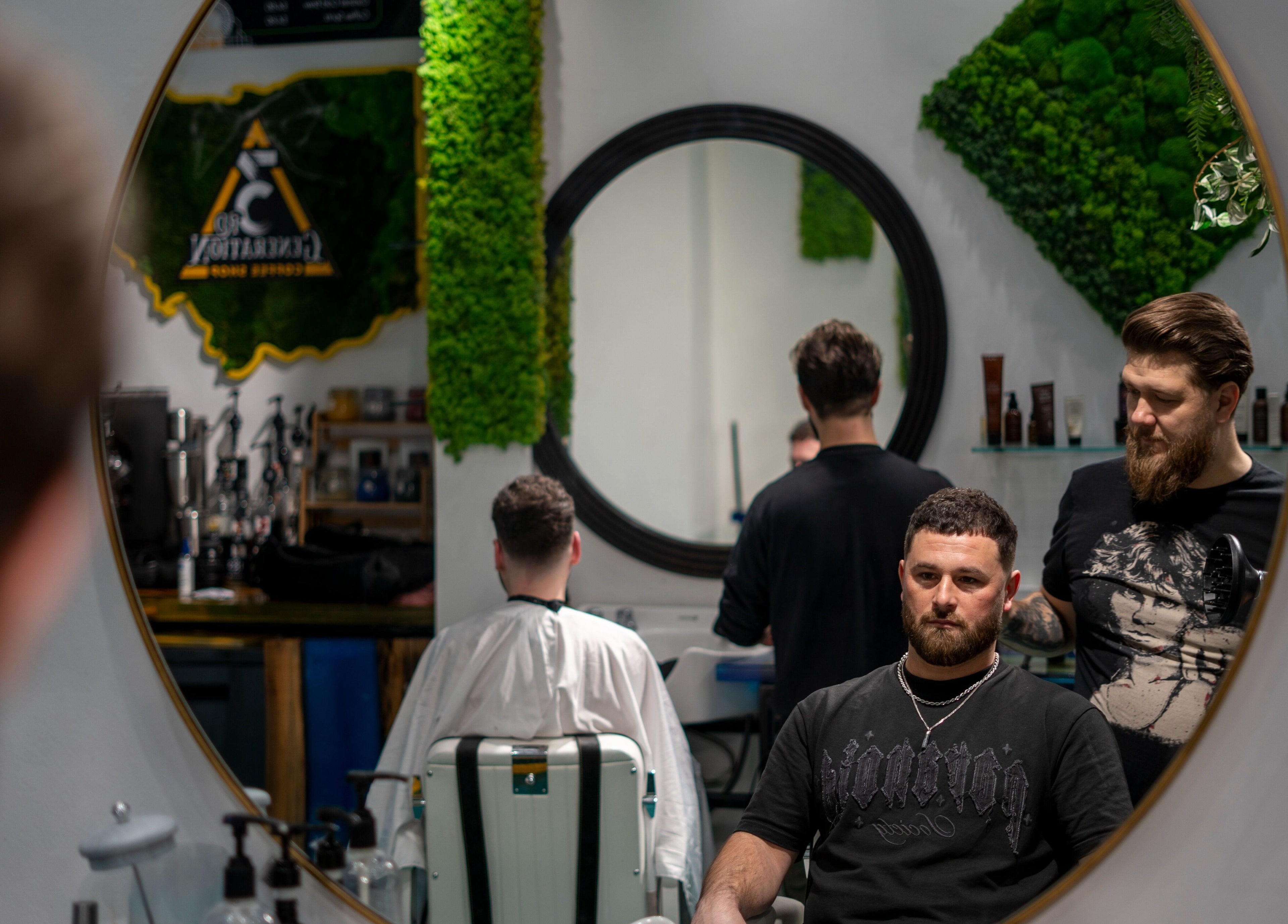 Barber styling client in mirror at 3rd Generation Grooming, London, England, GB.