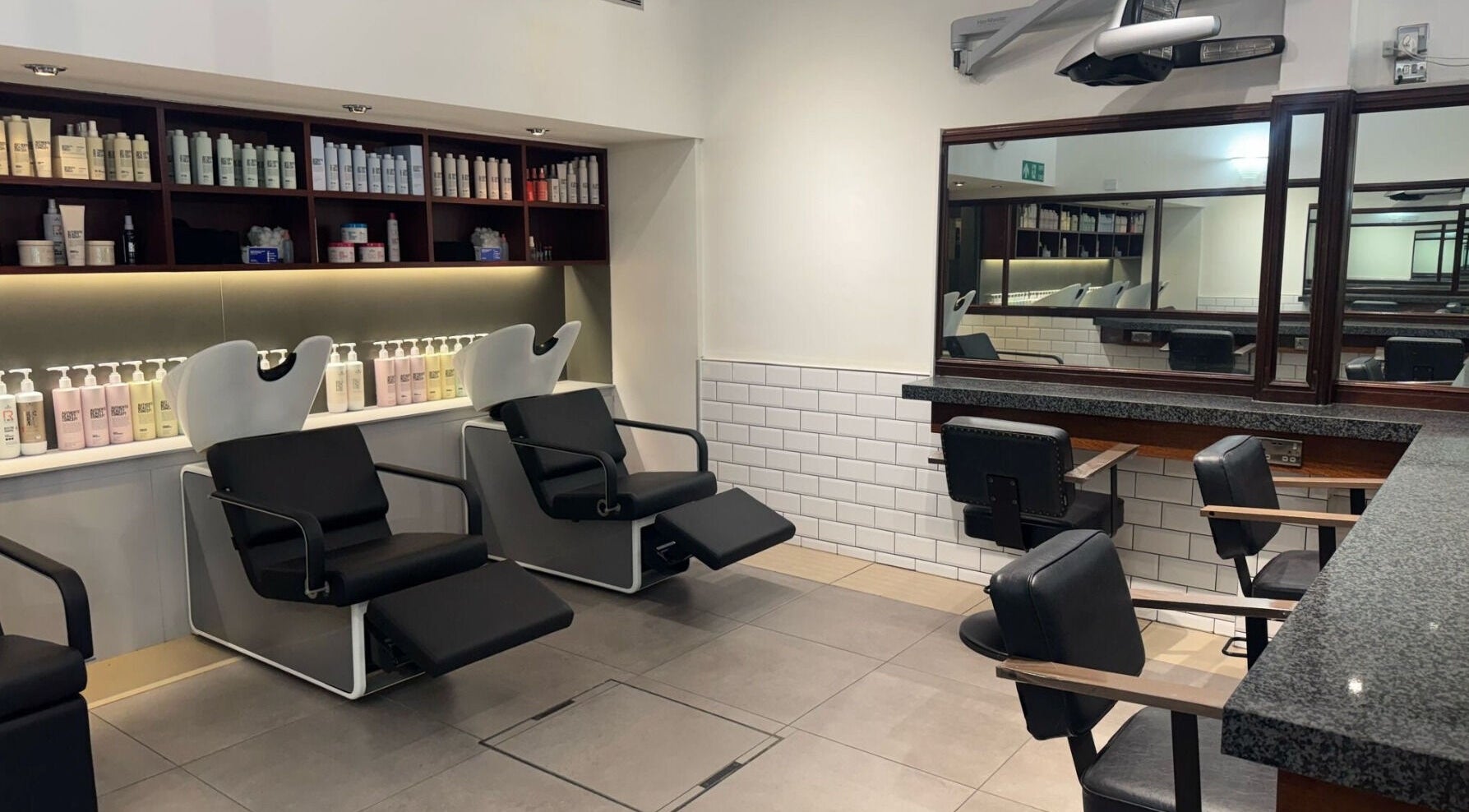 Stylish salon at Mahogany Hairdressing - Little Clarendon Street, Oxford, England, GB featuring modern black chairs.