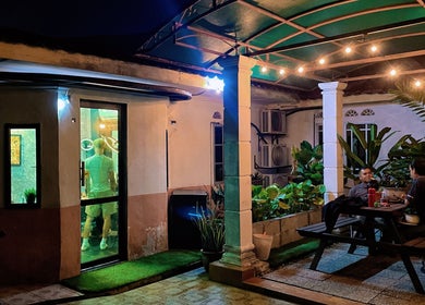 Room41 Barber's cozy outdoor seating area in Klang, Selangor, MY with glowing string lights and lush plants.