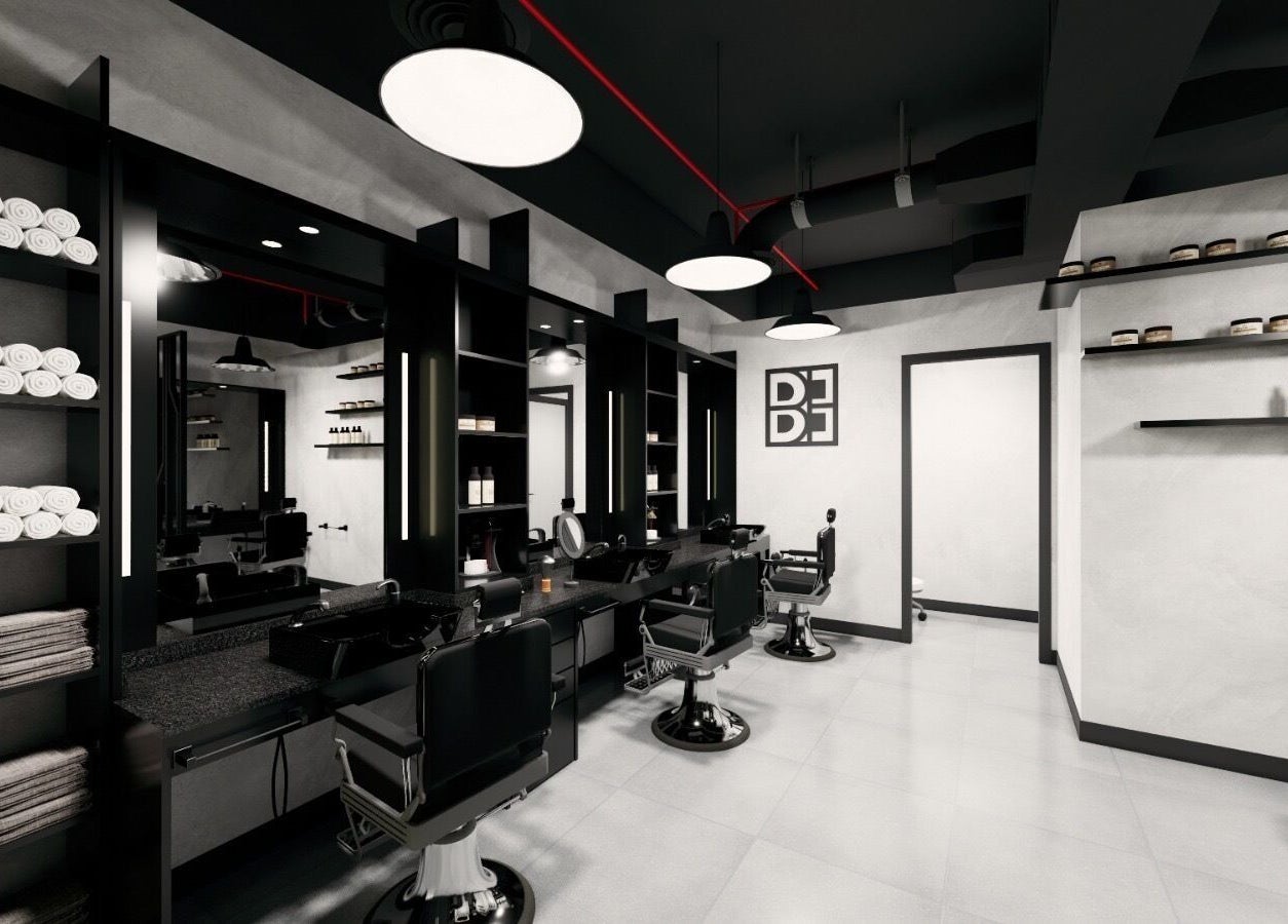 Modern interior of Budz and Broz Barbershop in Dubai, Dubai, AE with sleek black chairs and elegant shelving.