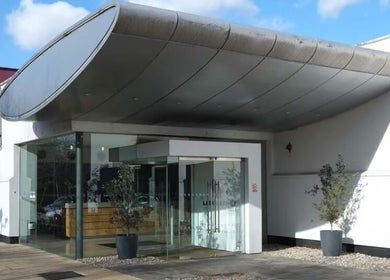 Entrance to Holistic Calibration, London, England, GB with sleek design and large glass doors.