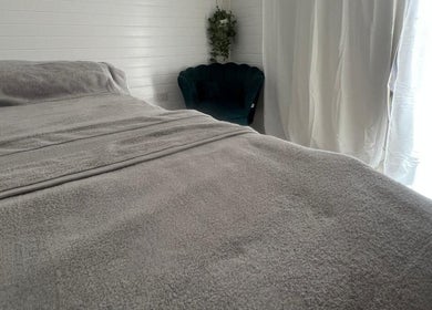 Cozy treatment room at BelleVie Wellness, Liverpool, England, GB with a plush bed and elegant decor.