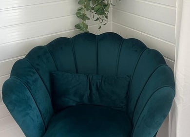 Elegant teal shell chair in BelleVie Wellness, Liverpool, England, GB, offering relaxation in a chic setting.
