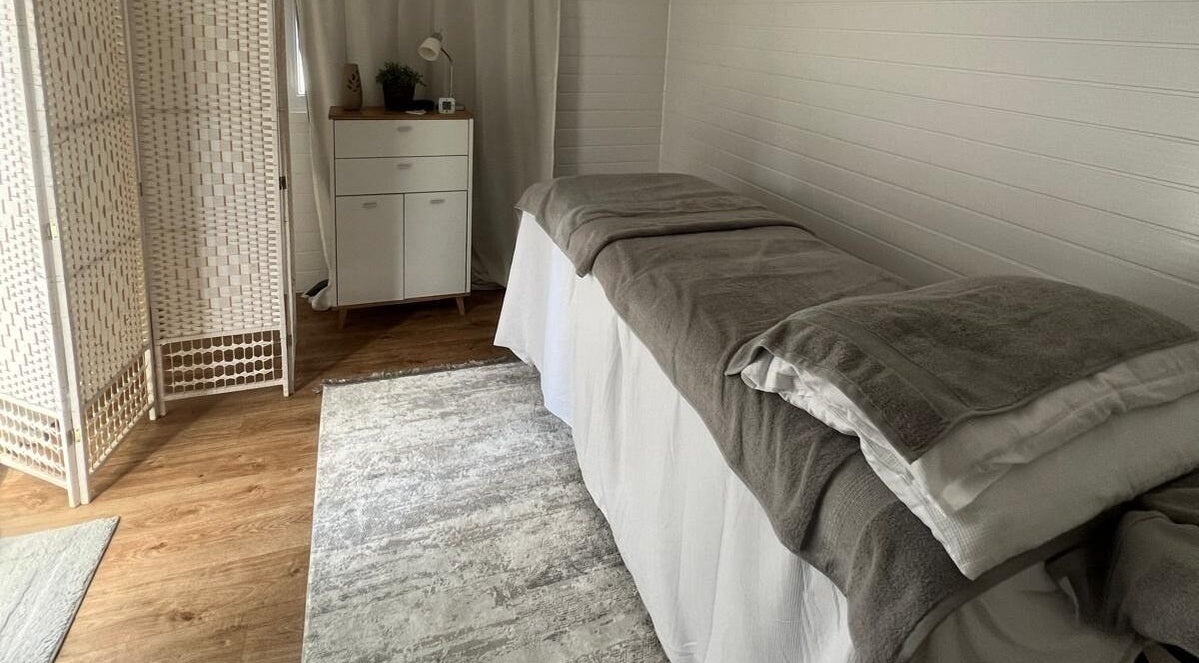 Relaxing massage room at BelleVie Wellness, Liverpool, England, GB, featuring soft lighting and cozy decor.