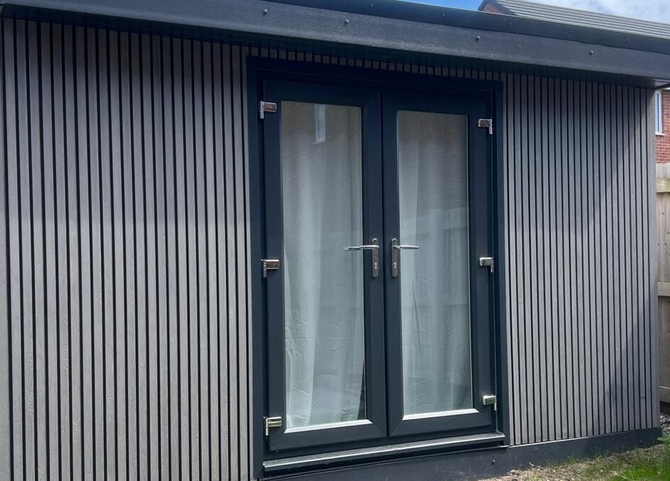 Modern cabin exterior at BelleVie Wellness, Liverpool, England, GB with sleek vertical paneling and glass doors.