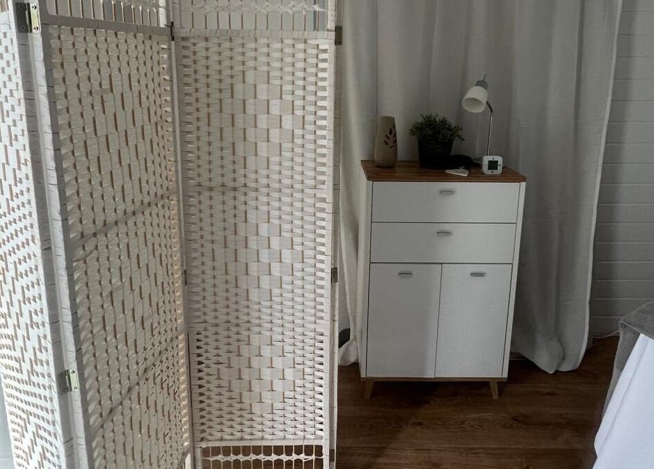 Calming decor at BelleVie Wellness, Liverpool, England, GB, featuring a woven room divider and white cabinet.
